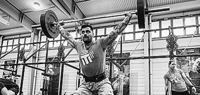EMT competitor performing an overhead snatch with an Olympic barbell, black-and-white photograph