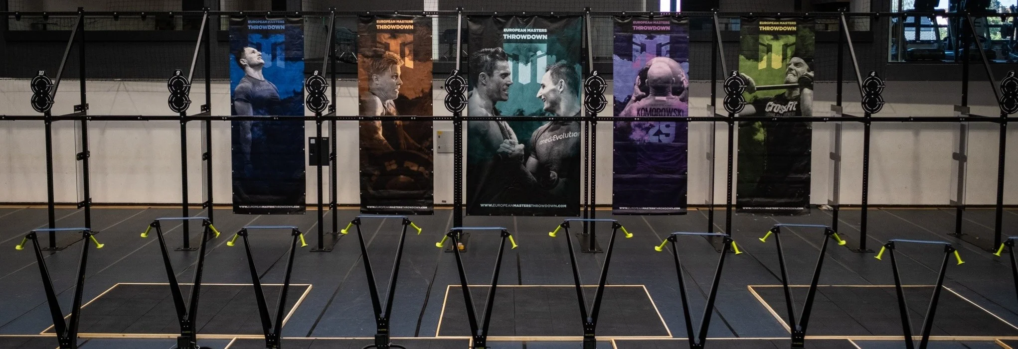 EMT competition floor pre-event setup — EMT branded banners and Concept2 rowing ergometers prepared for the day